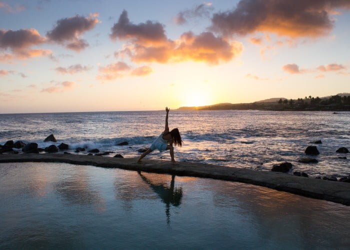 a woman doing yoga on stone