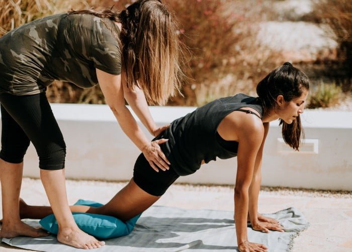 a woman doing yoga on the beach