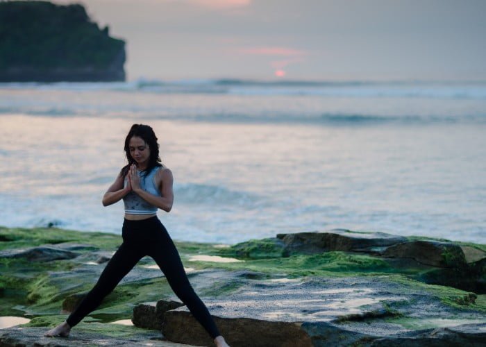 practicing yoga on beach