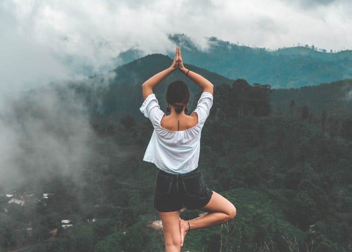 a woman doing yoga in mountains
